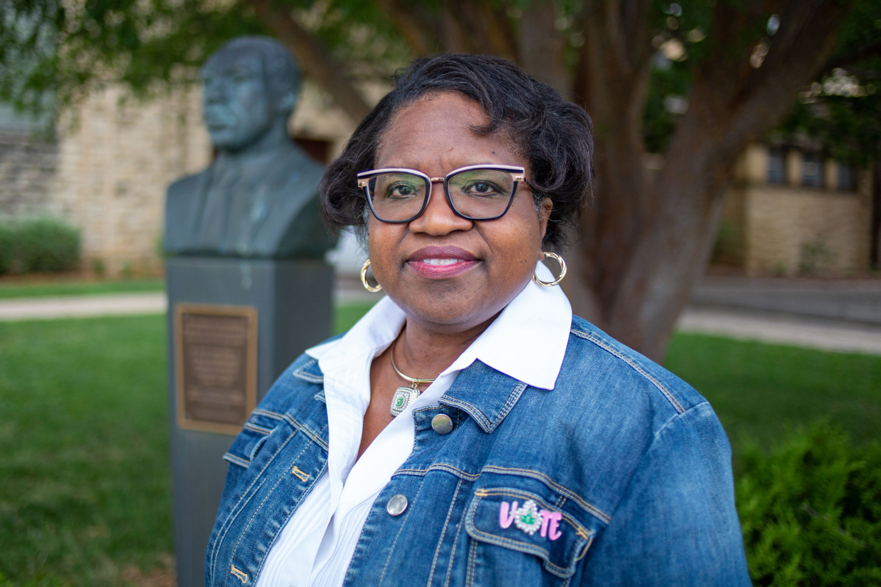 Patricia Hudgins, associate director of the K-State Career Center, smiles close to the MLK statue outside Ahearn.